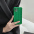Model holding green Textured Woven Case. Intricate 3D woven-style texture on protective silicone.