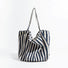 Front view of navy blue and white striped canvas tote, classic nautical look suited for outdoor picnics and boat trips.