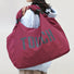 Model carrying a  Touch Nylon Weekend Bag in claret, ideal for errands and gifting.