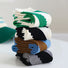 Angled view of Stacked twill cutout socks in green, black, brown, and gray with white and blue accents.