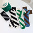 Front view of Four pairs of twill cutout socks in black, green, brown and blue.