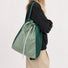 Model carrying the green convertible 2-way nylon backpack as a shoulder tote bag.