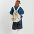 Model wearing cream backpack from behind; minimalist sporty look suited for active lifestyles and hiking.