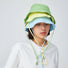 Model wearing green Ultralight Quick Dry Bucket Hat, showcasing technical nylon for rapid moisture-wicking.