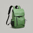 Three-quarter angle view of the forest green waterproof flap backpack showing side mesh pocket.