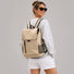Back view of a model carrying the khaki flap laptop backpack.