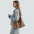 Camel vintage suede hobo bag worn as a minimalist daily shoulder bag.