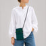 Model wearing the Dark Teal pleated knit mini bag over a plain white button-down shirt.