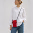 Model styling the bold red pleated knit mini crossbody pouch over daily casual wear.