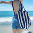 Model carrying a blue striped tote bag on the shoulder, ideal for city walks and gifting.