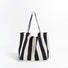 Angled view of Black and white wide stripe canvas tote bag with shoulder straps and an open top.