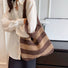 Model carrying a brown striped bag on the shoulder, easy for commuting and weekends.