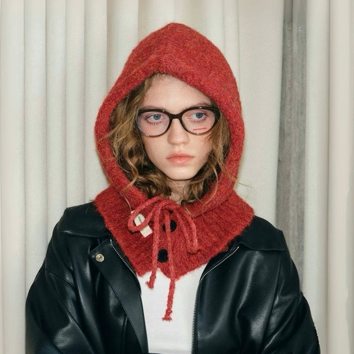 A model wearing a wine red knitted balaclava with a black leather jacket, showcasing the drawstring and button details.