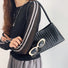 Model carrying a black bag on shoulder , ideal for city walks and gifting.