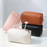 Four woven PU leather makeup bags: pink, brown, black, and white, with zip-top fastening.