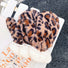 Dark leopard print fluffy gloves with plush texture; warm animal-print accessory for winter outings.