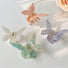 Four acrylic butterfly hair claws in white, pink, purple, and green with alloy springs.