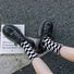 Model wearing a pair of black plaid cotton socks, great for casual wear and light workouts.