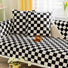 Two black Checkerboard Pillow Covers on a couch with matching blanket, ideal for home decor.
