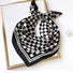 A black and white checkerboard scarf tied into a decorative bow.