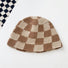 Khaki checkered bucket hat laid flat on a clean background, showcasing its artisanal crochet weave.