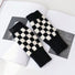 Black and white checkered knit gloves; timeless design perfect for retro-themed winter street styling.
