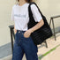 Model carrying the black Cloud Puff Tote Bag with a white T-shirt and jeans.