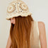 Model wearing beige Floral Crochet Hat. Subtle neutral palette with sophisticated handmade floral details.