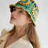 Model wearing green Floral Crochet Hat. Fresh nature-inspired hues with unique artisanal floral designs.