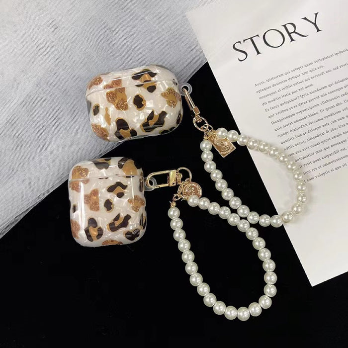 Two sizes of Leopard print silicone AirPods cases with pearl wrist strap and gold charms.