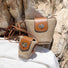 Front view of Two mini PU mix raffia straw bucket crossbody bags, one large and one small.