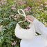 Model carrying a white Monogram Crescent Bag handheld,.