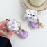Purple heart-shaped silicone AirPods case cover with a matching puffy heart charm and pearl accents.