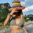 Lifestyle view of model with rainbow straw hat against mountain backdrop.
