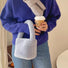 Model carrying a Sherpa Bucket Handbag in blue, ideal for errands and gifting.