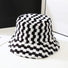 Fluffy black and white checkered sherpa polyester bucket hat, designed for cozy and stylish cold-weather warmth.