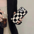 Model holding classic black and white checkered phone case in a soft, plush sherpa material.