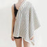 Model having a white-black striped bath towel draped over her shoulder.