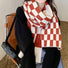 Model wearing Thick wool scarf with a red and white checkered pattern, great for office.